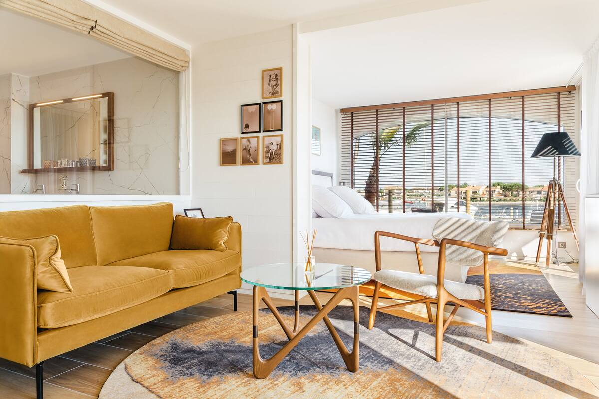 Ein modernes Wohnzimmer mit einer Couch, einem Glastisch und einem Sessel.