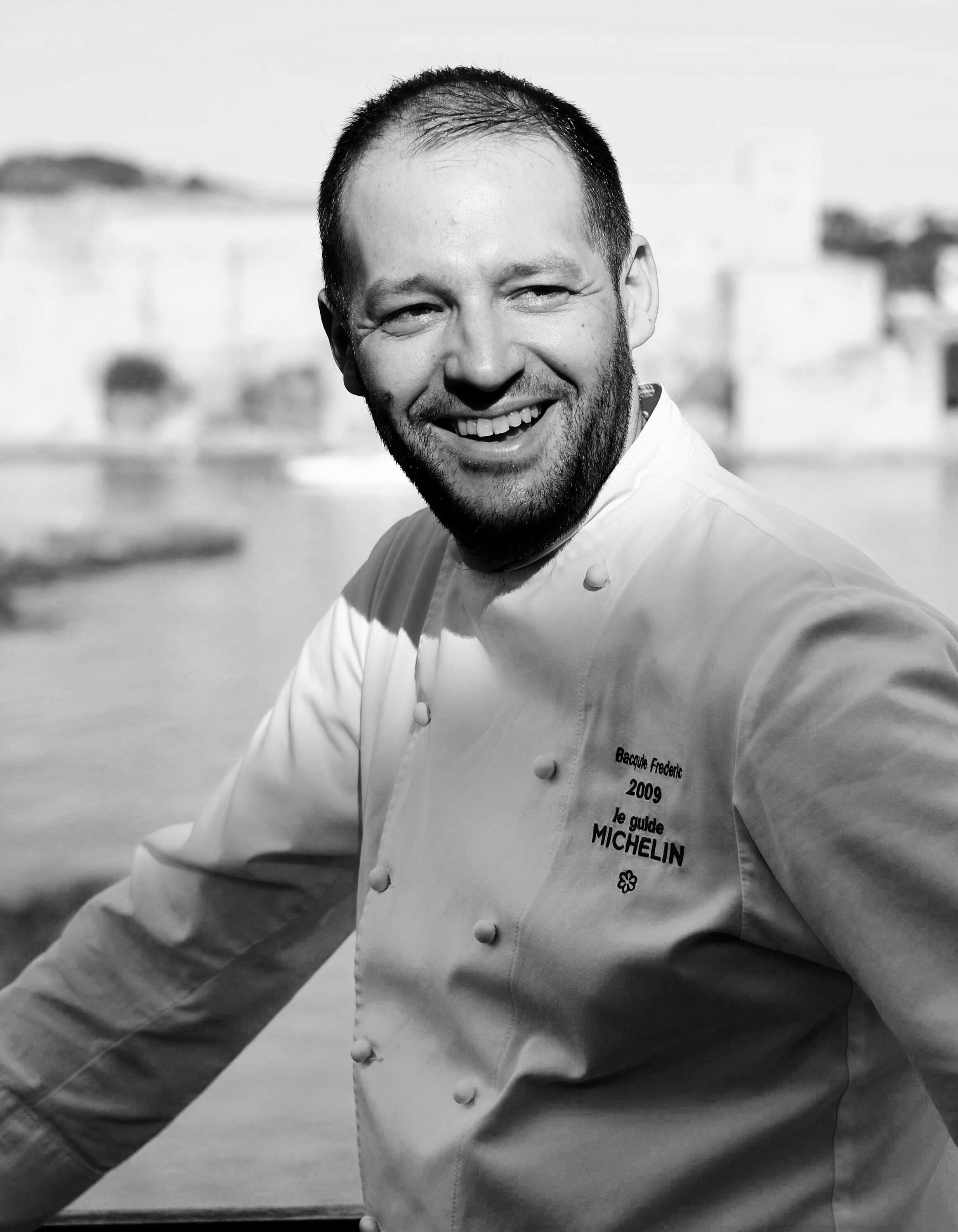 A chef in a chef's coat with text on the left side.