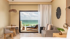 Une chambre d’hôtel avec vue sur la plage, un canapé, une petite table et une chaise.