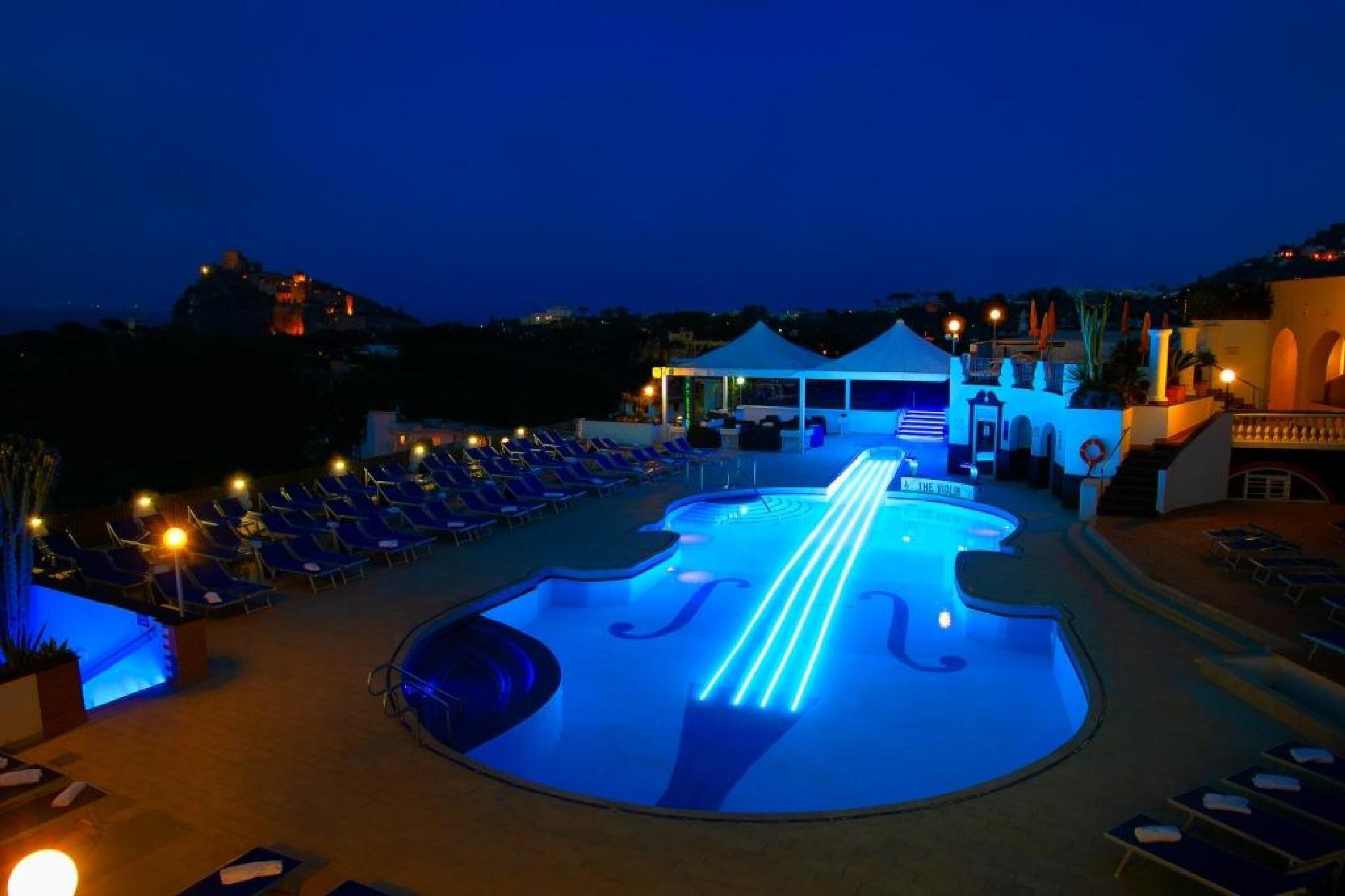 A pool area with lounge chairs and a tent.
