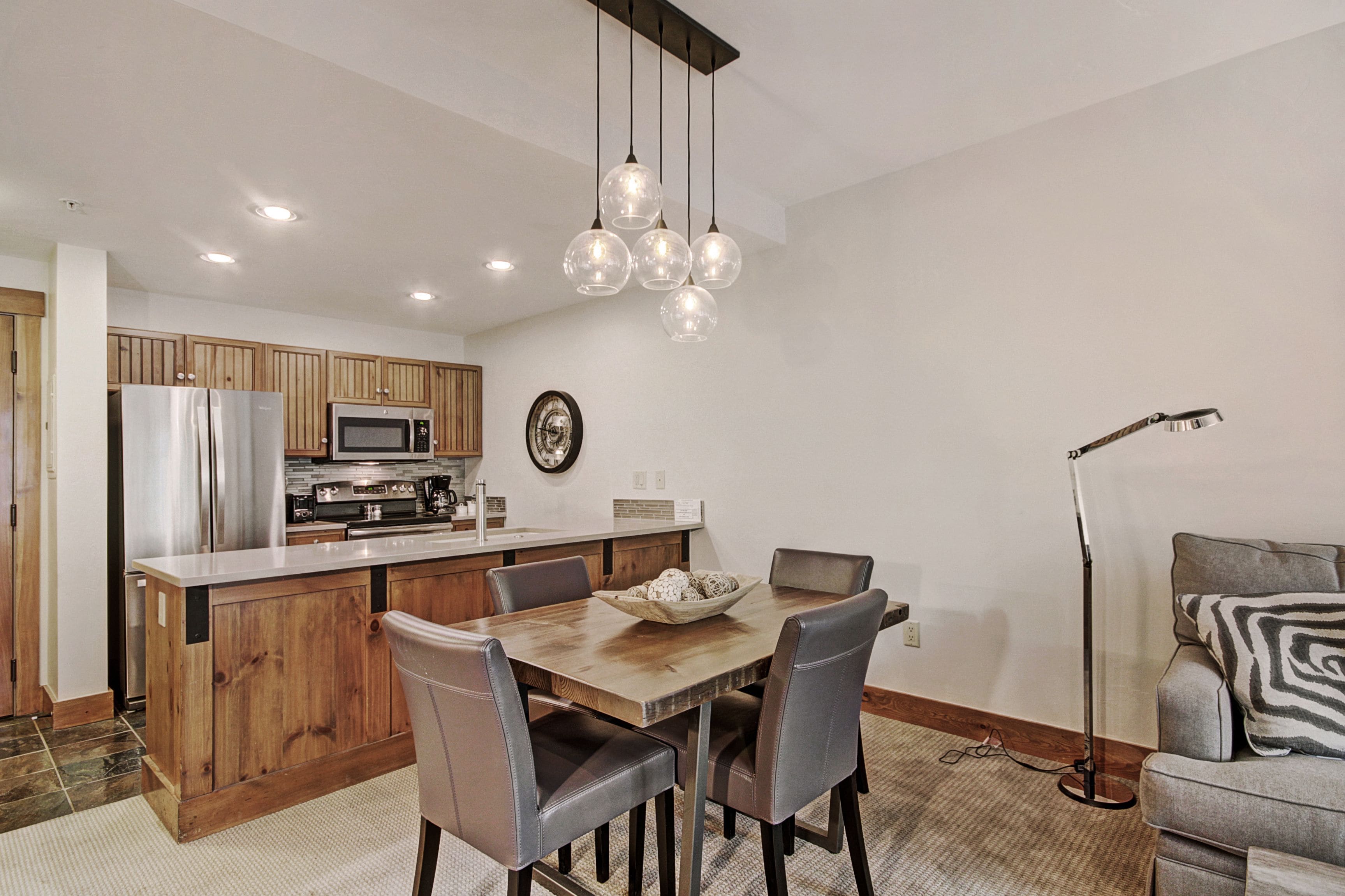 A modern kitchen with wooden cabinets, stainless steel appliances, and a central island with seating.