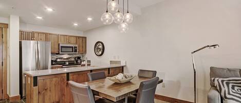 A modern kitchen with wooden cabinets, stainless steel appliances, and a central island with seating.