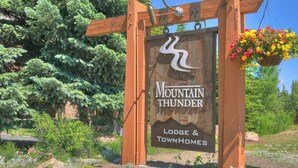 A wooden sign with the text "Mountain Thunder Lodge & Townhomes".