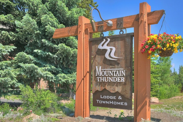 Un letrero de madera con el texto "Mountain Thunder Lodge & Townhomes".