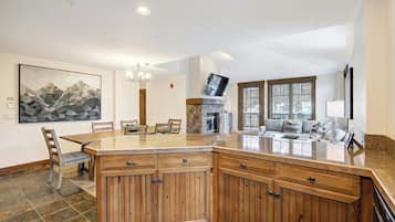 Une cuisine spacieuse dotée d’un grand îlot central, de meubles en bois et d’un coin repas avec des chaises.