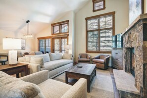 A spacious living room with a fireplace, large windows, and a cozy seating area. - Mountain Thunder Lodge, A Vail Resorts Property (Breckenridge)