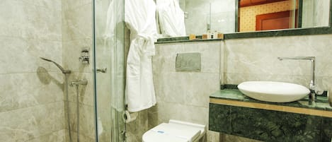 A modern bathroom with a glass shower enclosure, a toilet, and a sink.