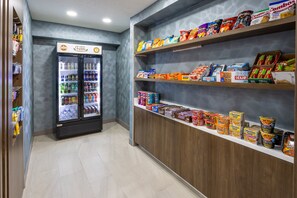 Ein Imbissstand mit gekühlten Getränken und verschiedenen verpackten Snacks.