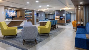 A hotel lobby with a reception desk, seating area, and a coffee station. - Holiday Inn Express & Suites Center Township by IHG (Monaca)