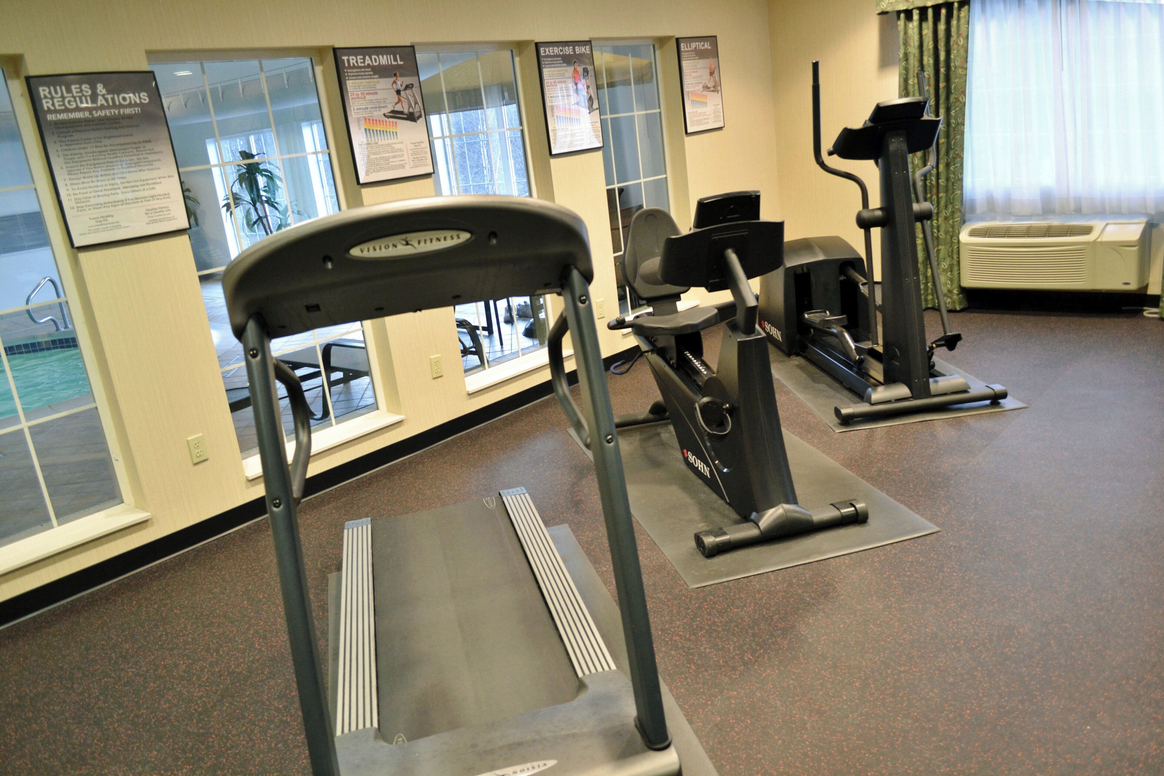 A gym with treadmills, stationary bikes, and elliptical machines.