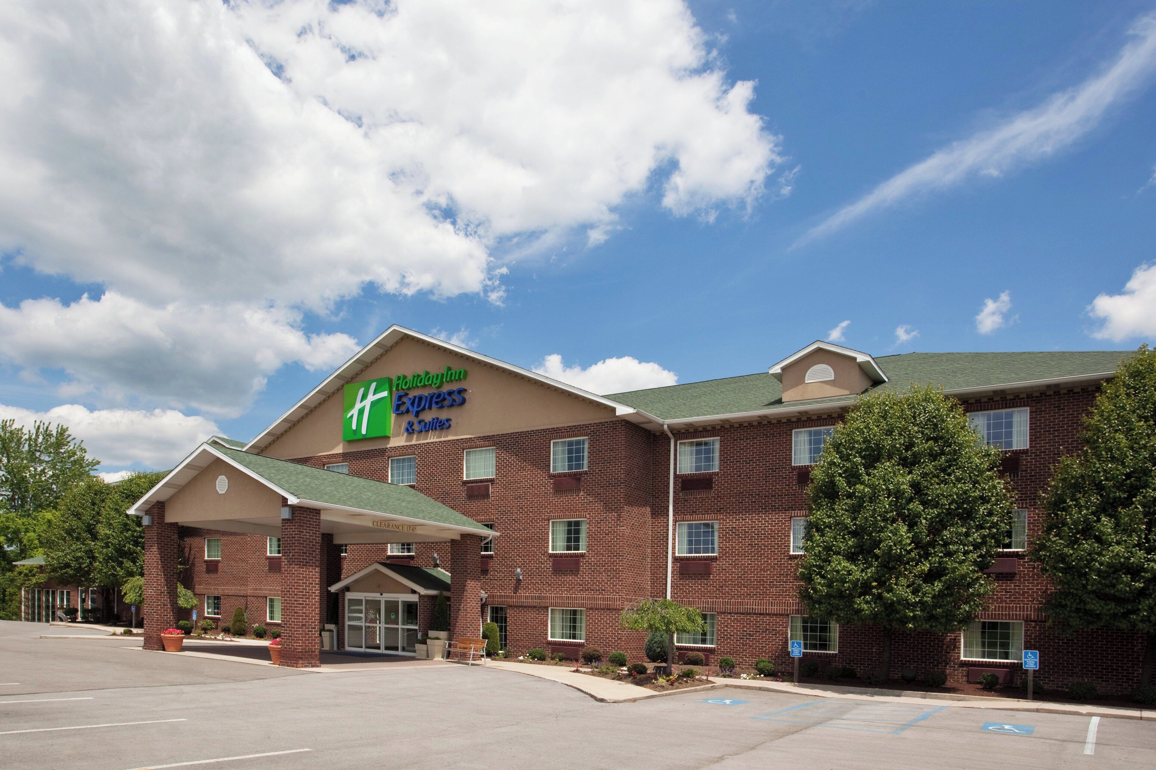 A Holiday Inn Express & Suites hotel with a brick facade, multiple windows, and a parking lot.