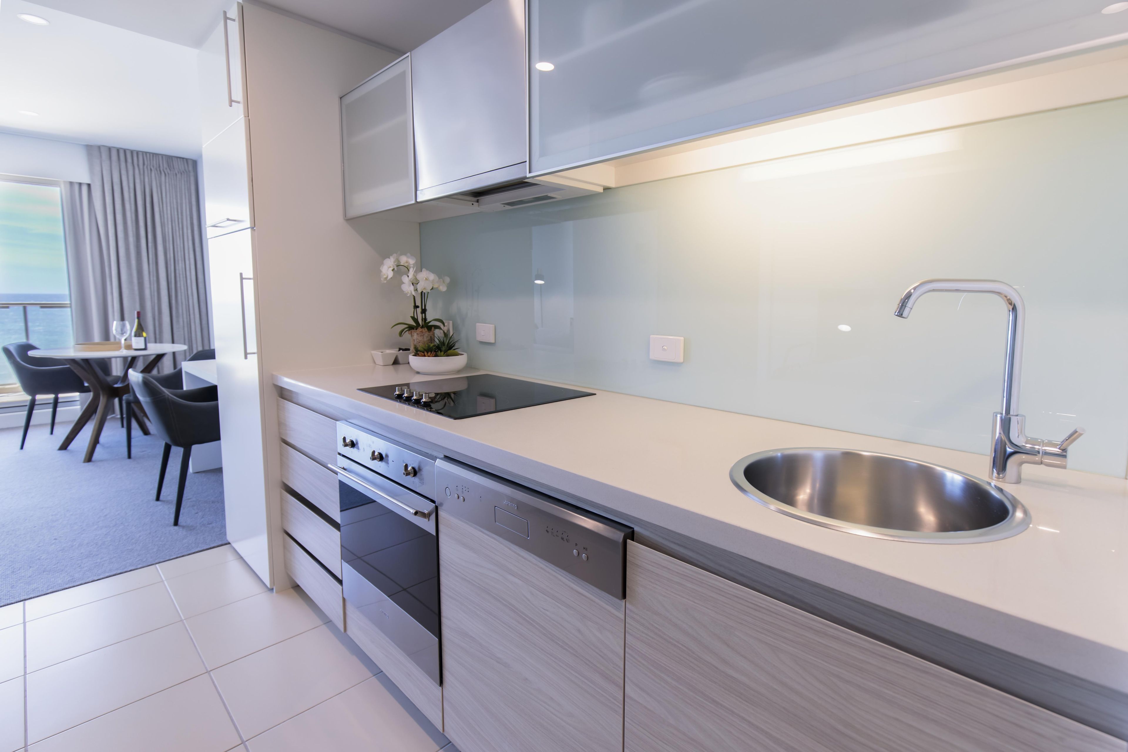 A modern kitchen with stainless steel appliances, a built-in oven, and a sink.