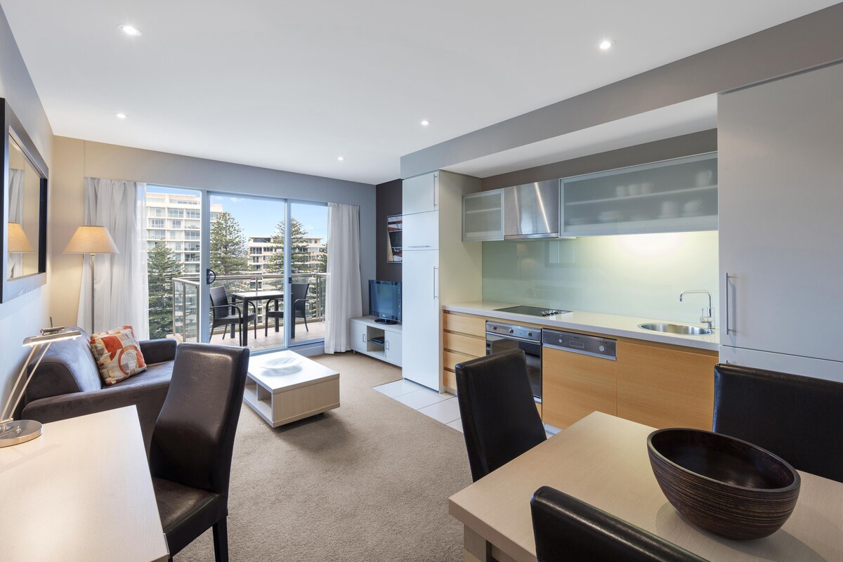 A modern apartment with a balcony, a dining area, a kitchen, and a living room.