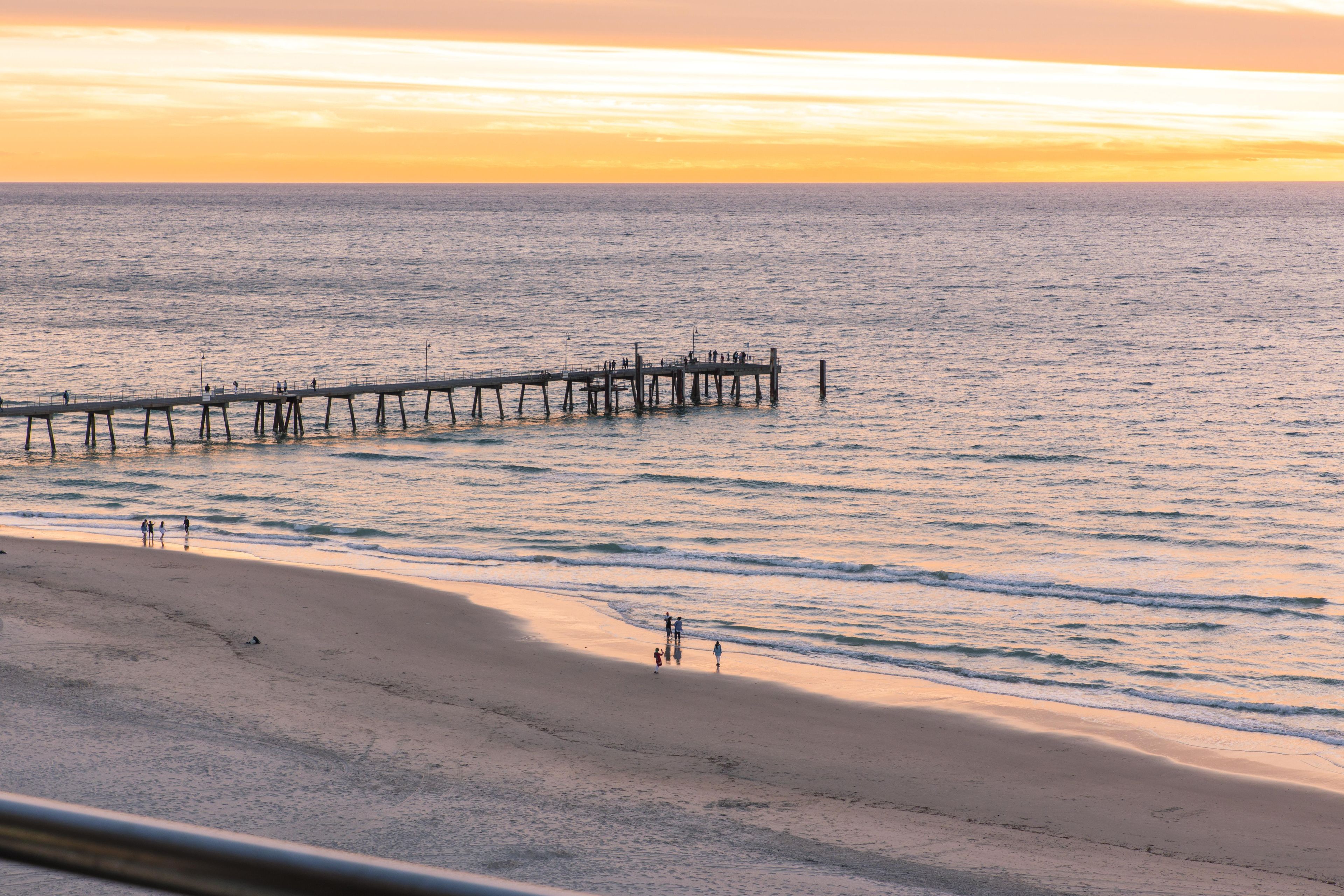 A beach with a pier extending into the water.