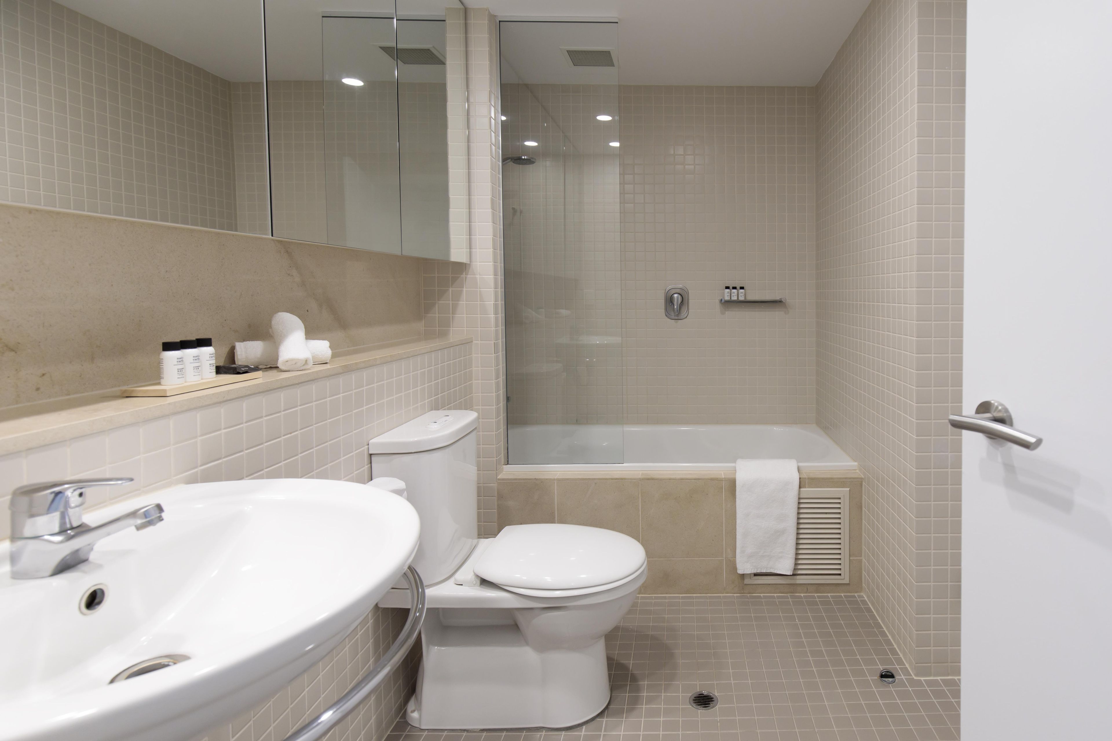 A modern bathroom with a sink, toilet, and shower area.