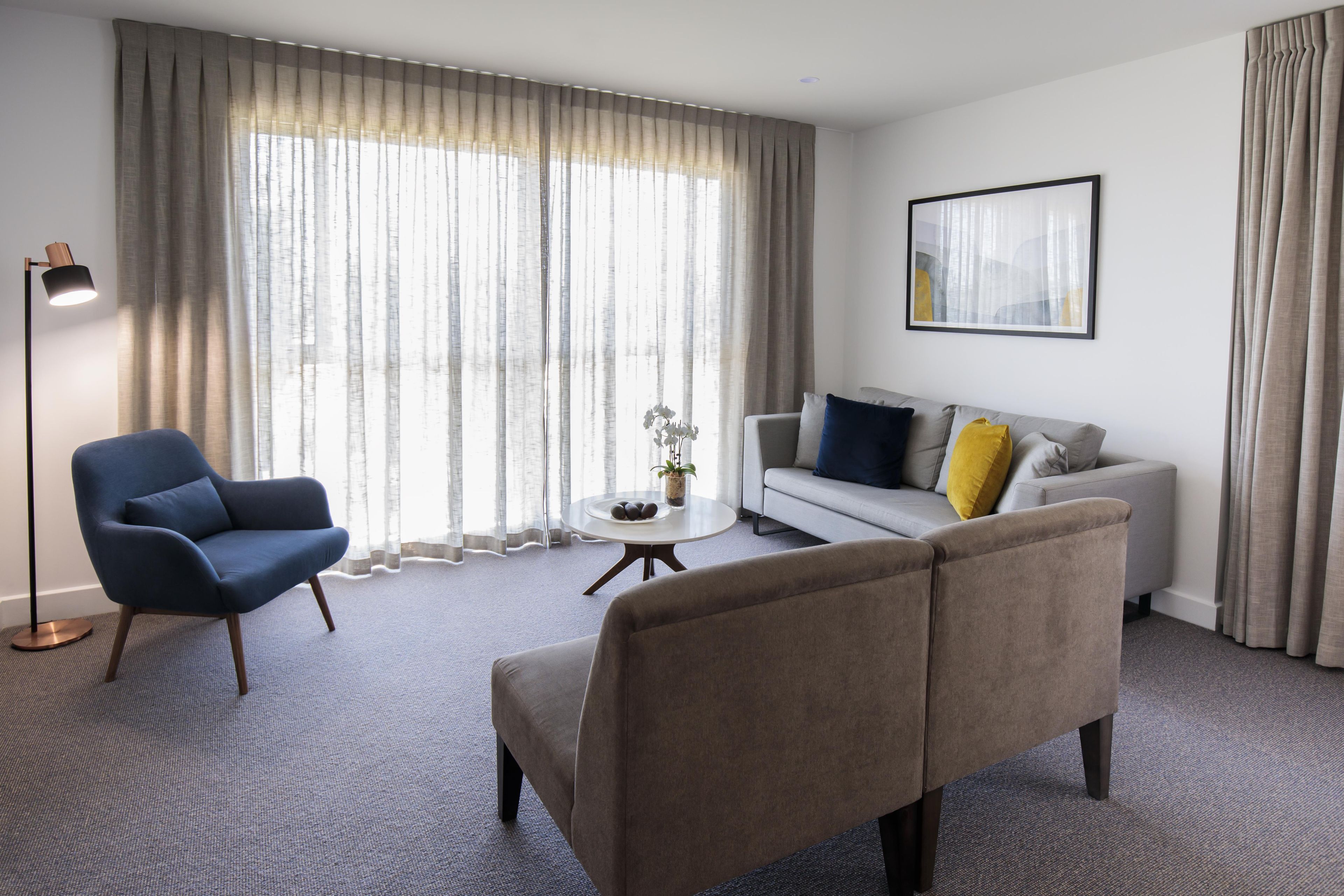 Una sala de estar moderna con un sofá, un sillón y una mesita de centro.