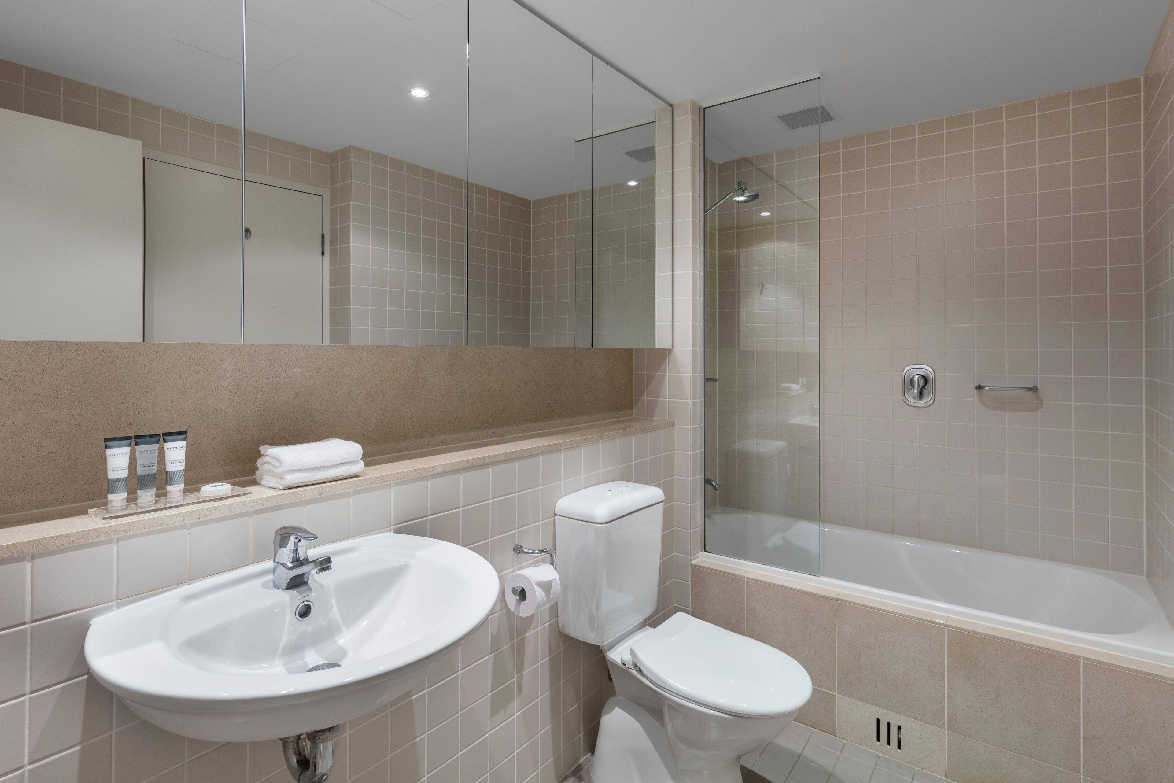 A modern bathroom with a sink, toilet, and glass-enclosed shower.