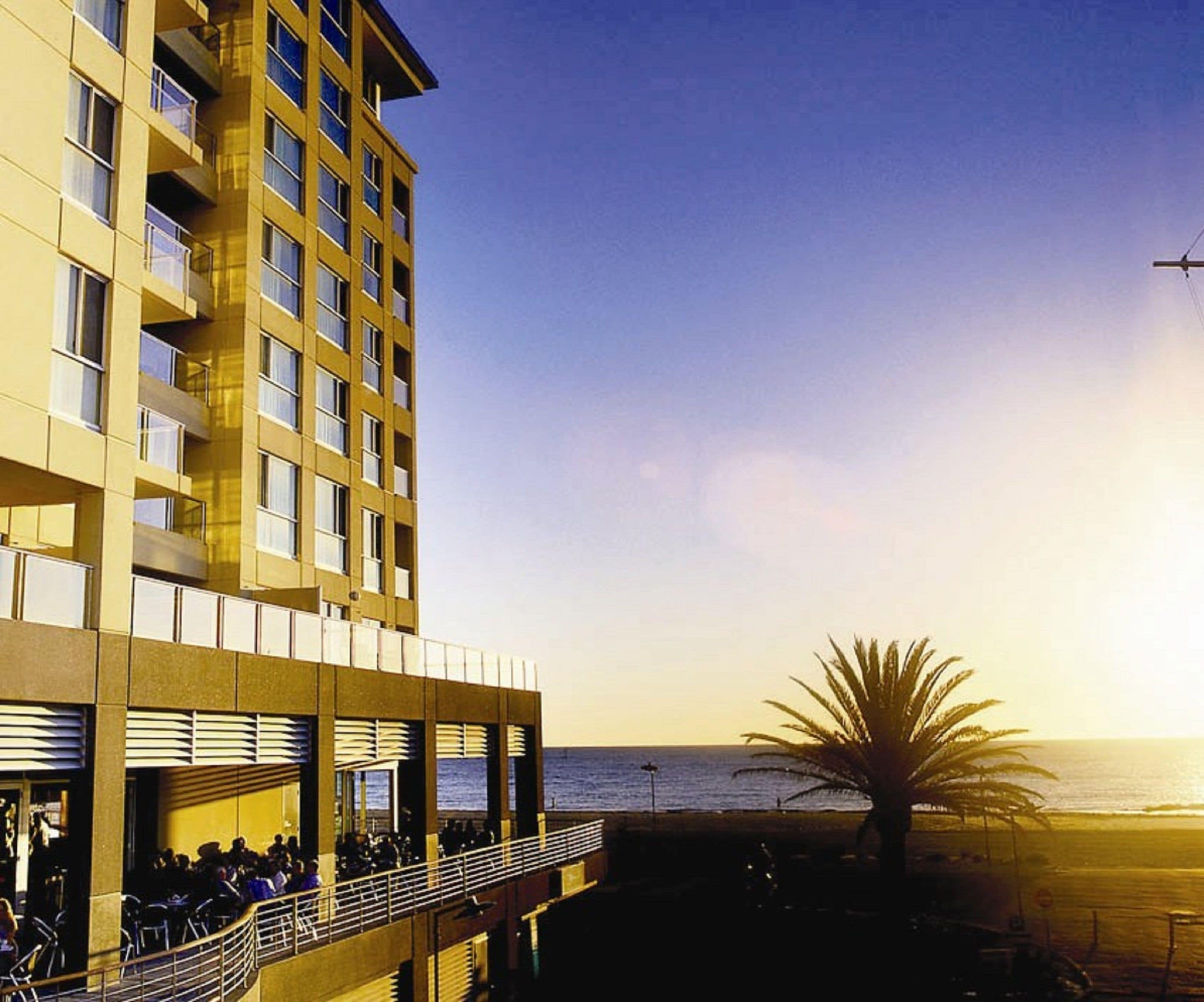 A hotel with a balcony overlooking the beach and ocean.