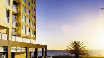 A hotel with a balcony overlooking the beach and ocean.