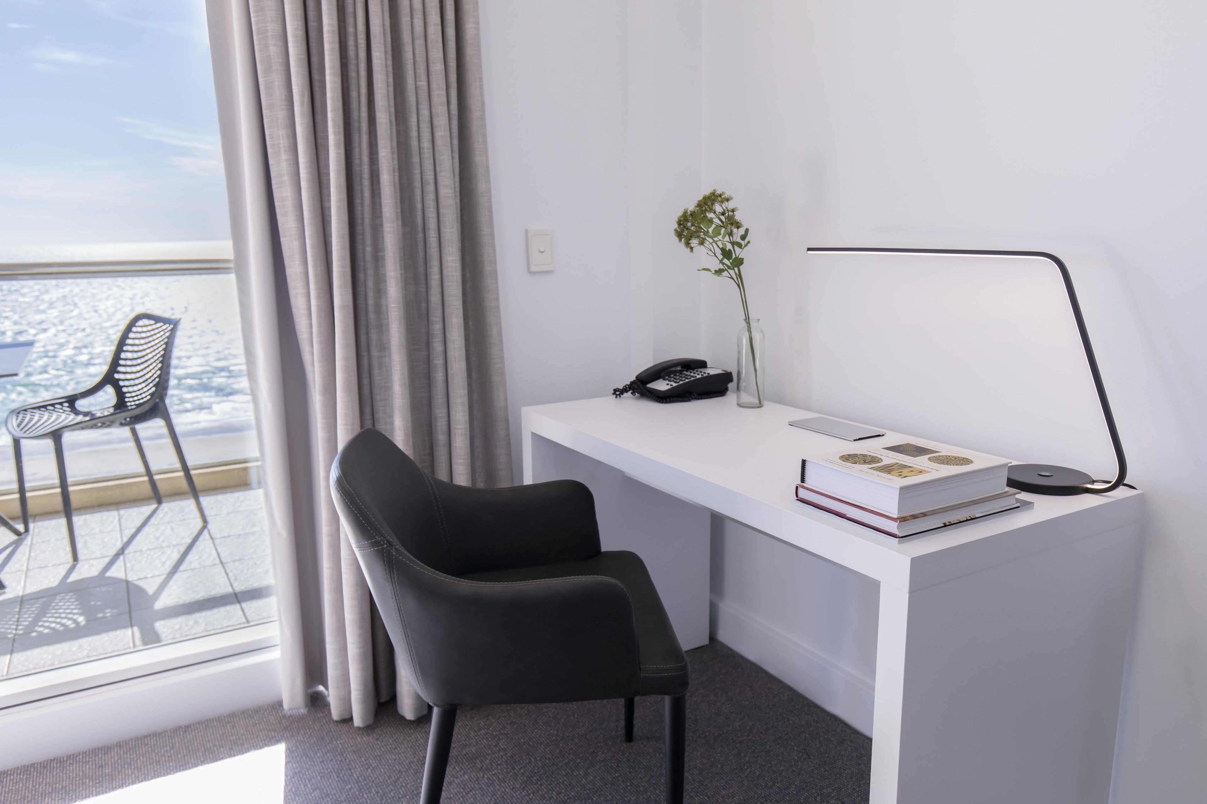 A modern office space with a desk, chair, and a view of the city.