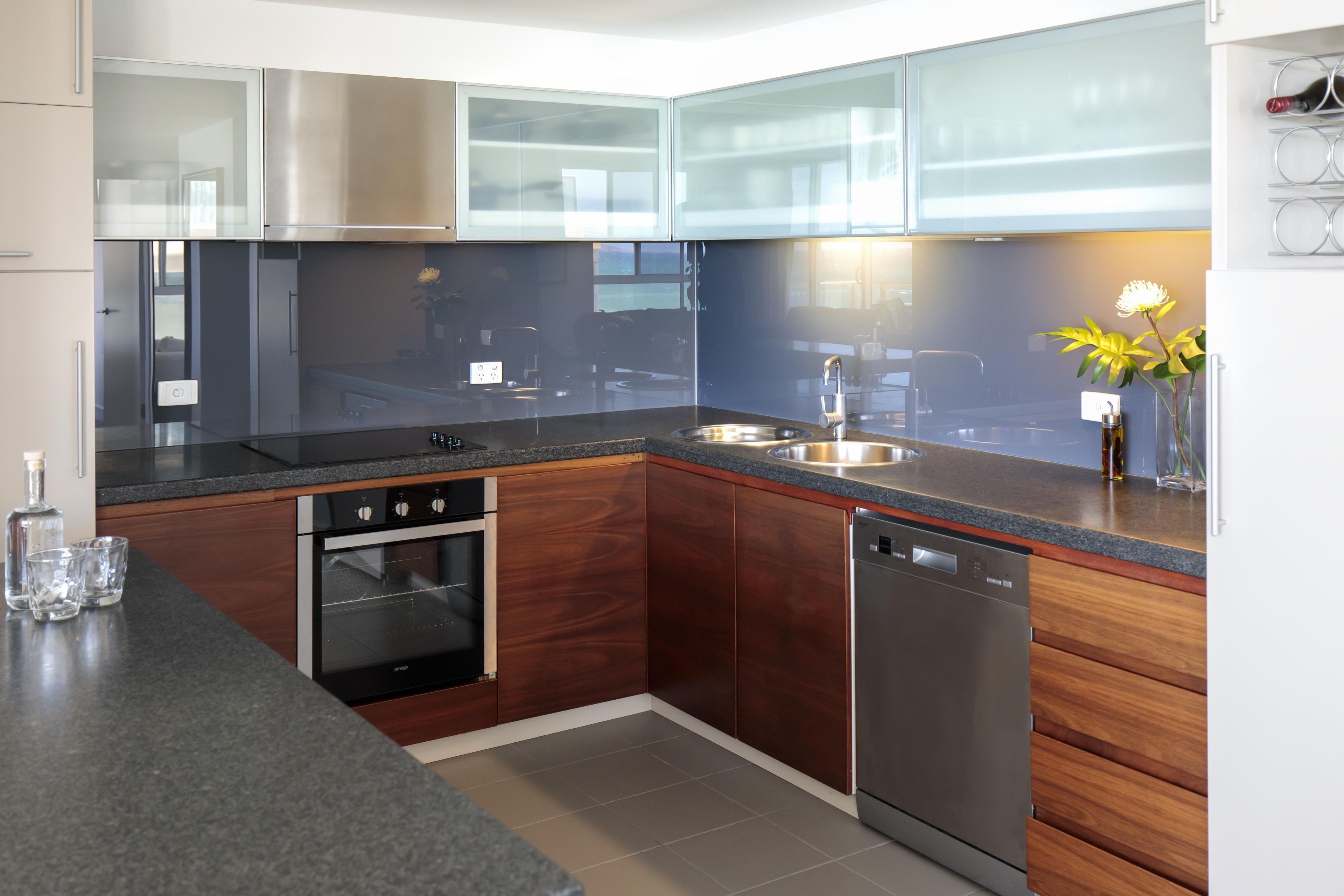 A modern kitchen with stainless steel appliances, wooden cabinets, and a granite countertop.