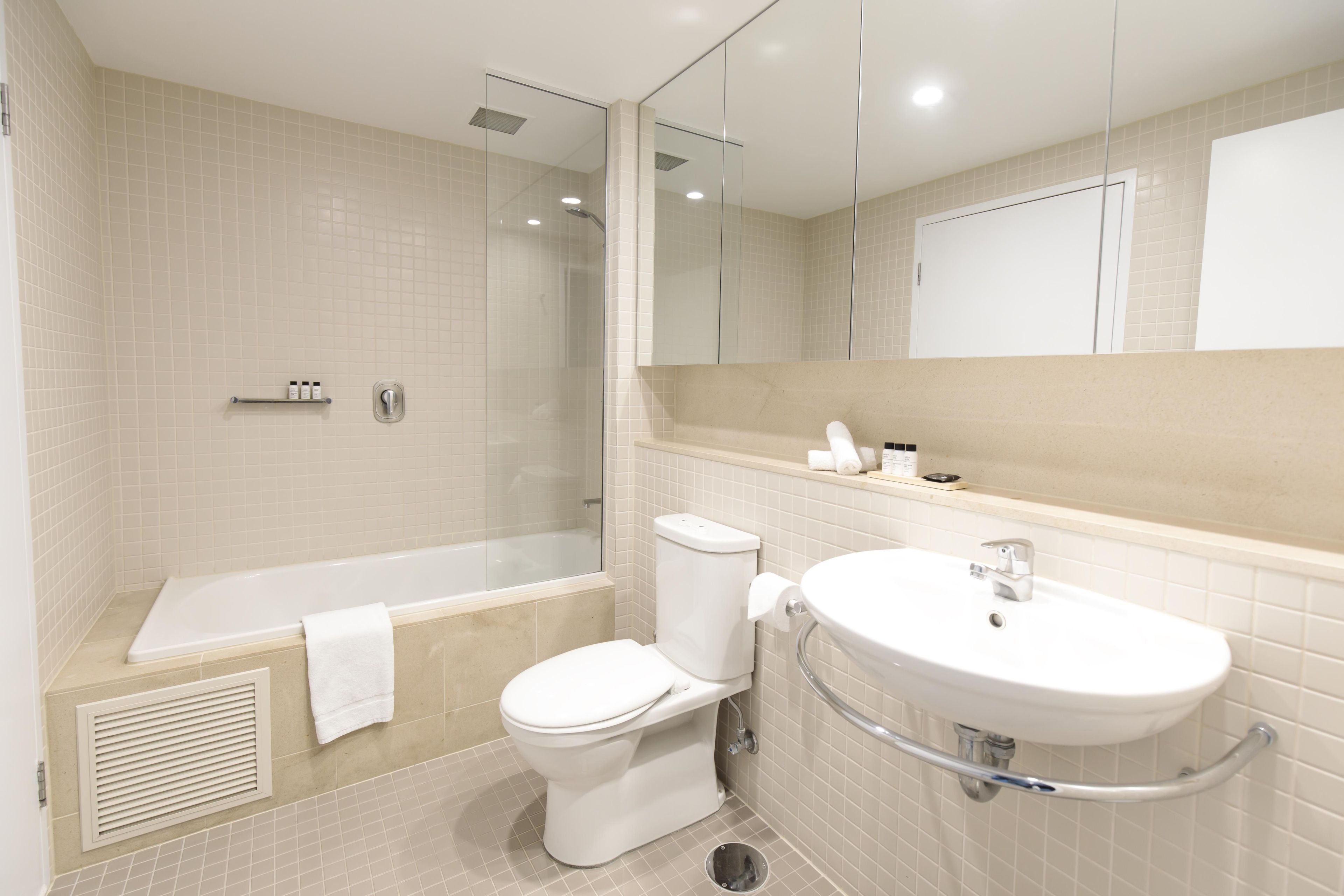 A modern bathroom with a bathtub, toilet, and sink.