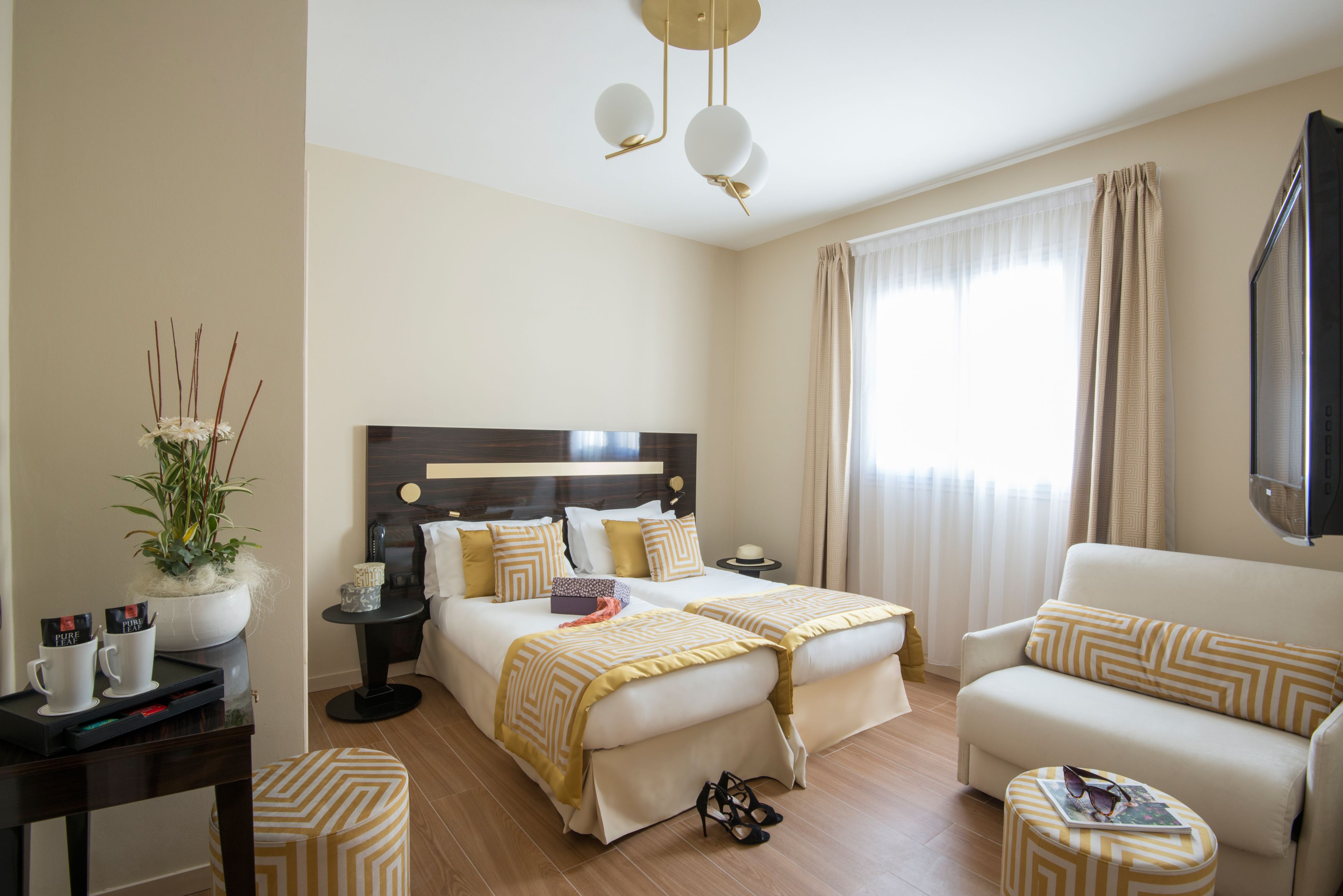 Une chambre d’hôtel avec un lit, un canapé, une petite table et un téléviseur.