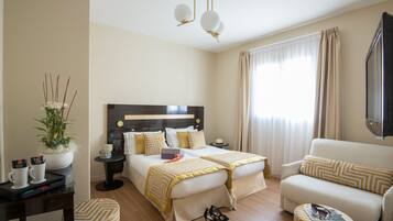 Une chambre d’hôtel avec un lit, un canapé, une petite table et un téléviseur.