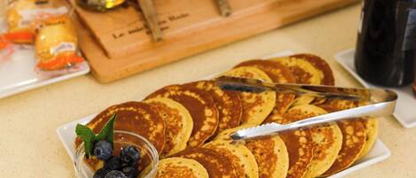 A breakfast buffet with pancakes, blueberries, and cranberries.