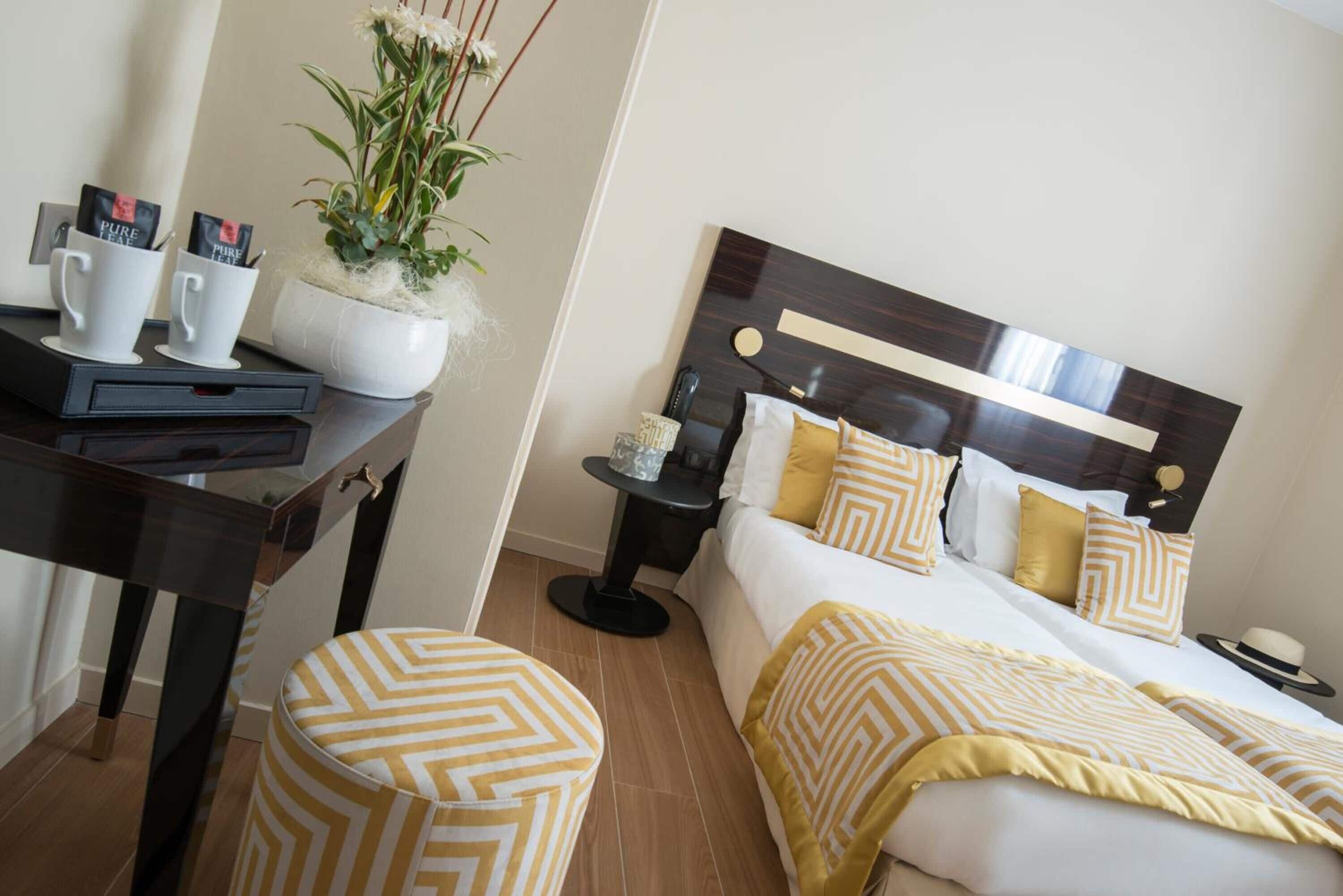 Une chambre d’hôtel comprenant un lit, une table de chevet et un bureau avec une chaise.