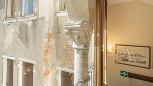 A stone column, a framed picture, and a directional sign in a building. - Ca' Valeri (Venice)