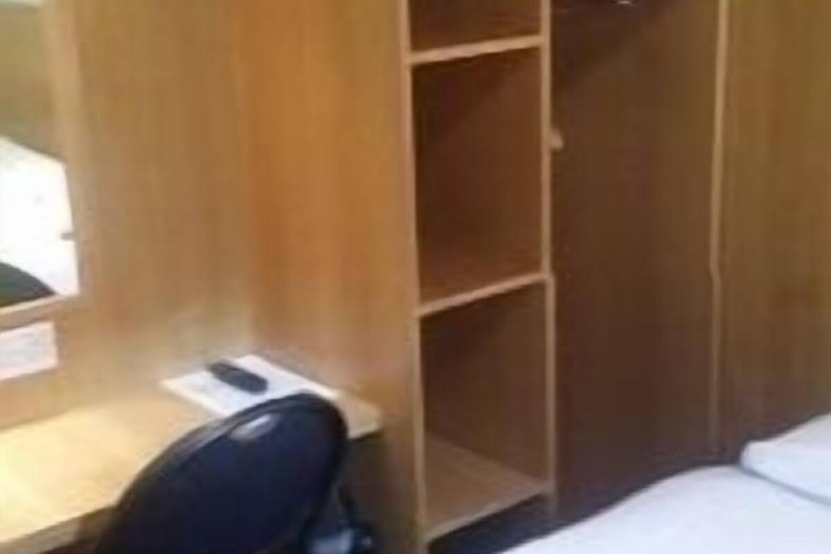 A room with a bed, a desk, and a wardrobe.