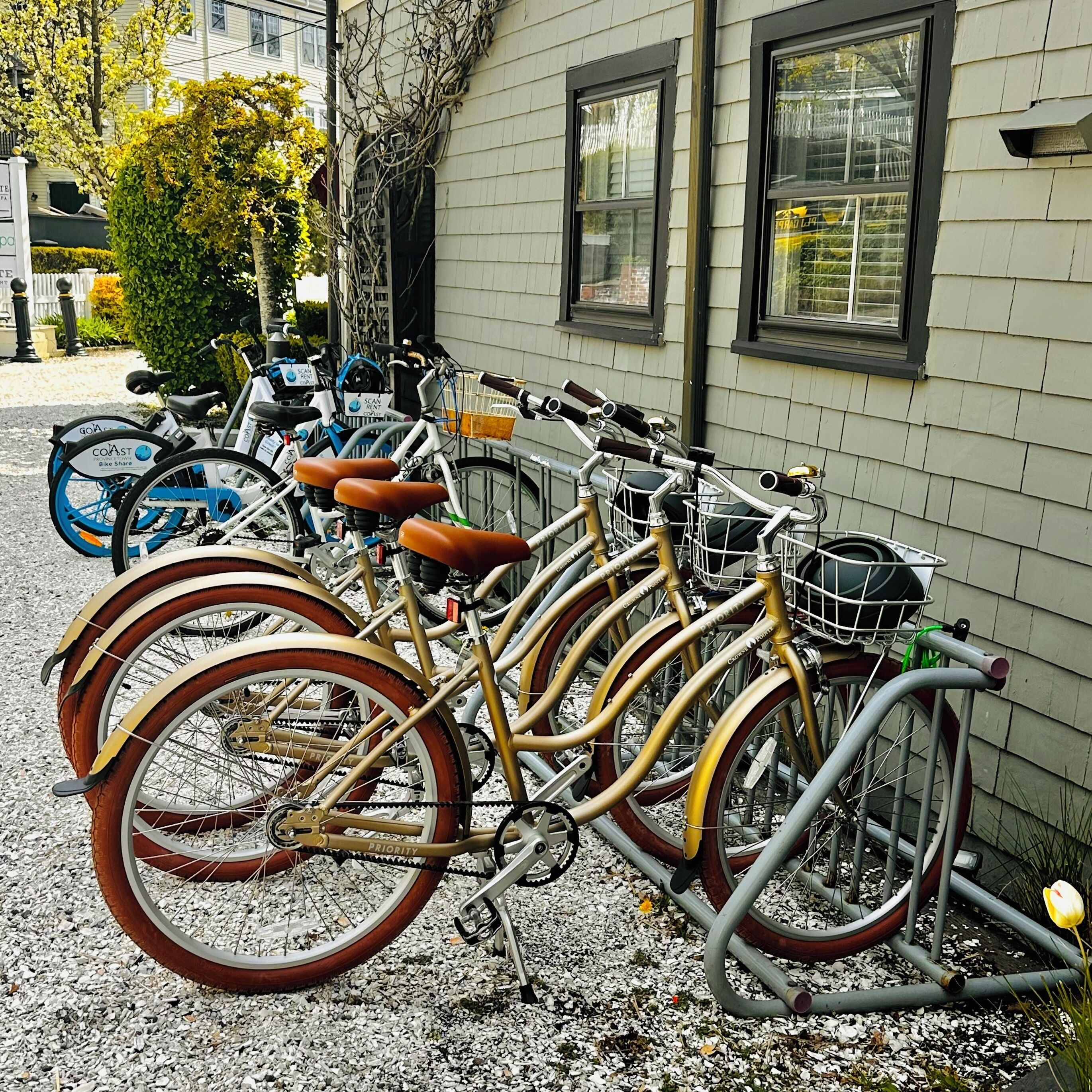 Une rangée de vélos est garée contre un bâtiment qui a une fenêtre.