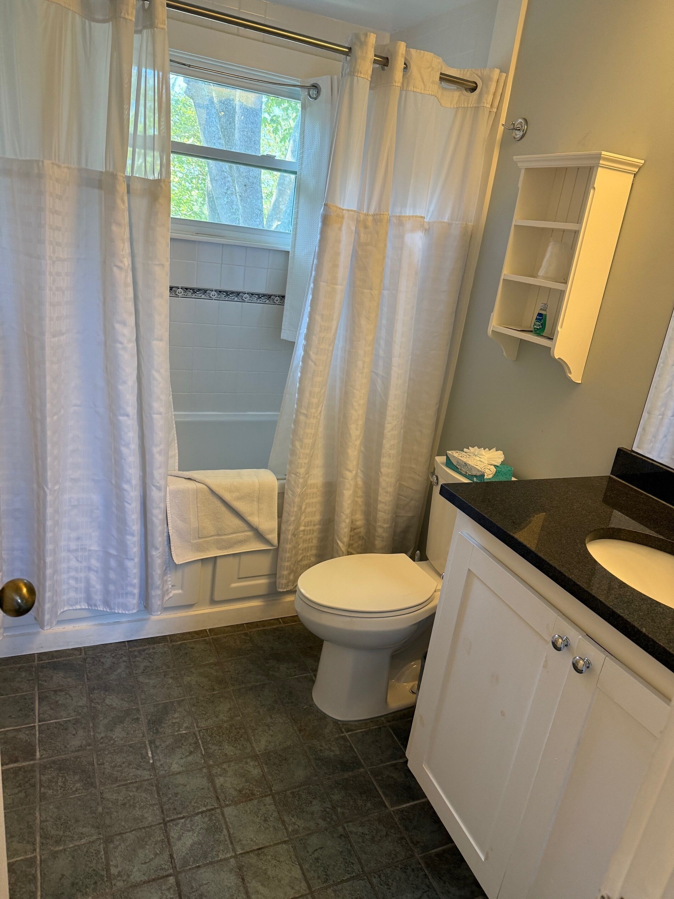 A bathroom with a bathtub, toilet, and sink.