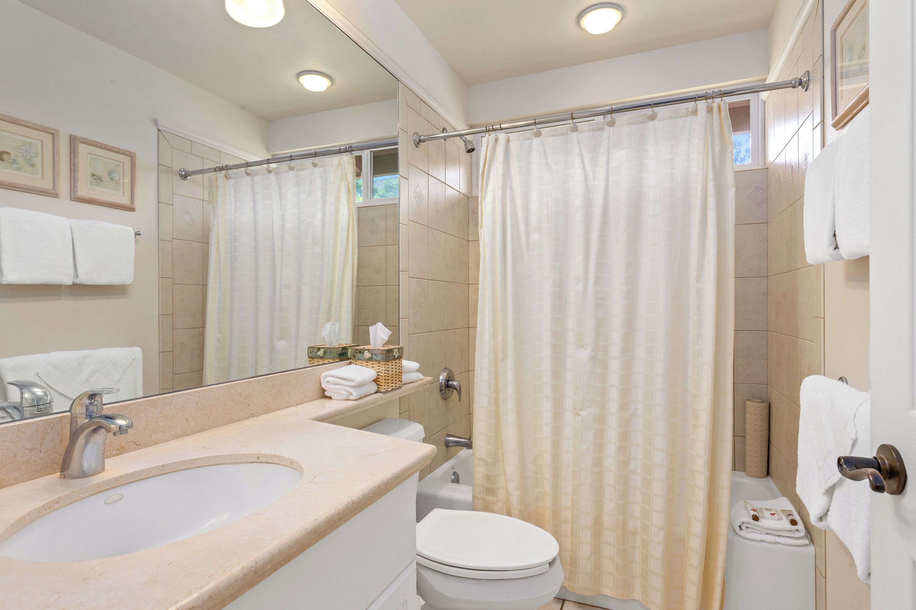 Ein Badezimmer mit Waschbecken, Toilette und Duschvorhang.