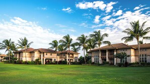 A residential area with multiple two-story houses, each with a balcony and surrounded by lush greenery and palm trees. - Waikoloa Colony Villas (Waikoloa)