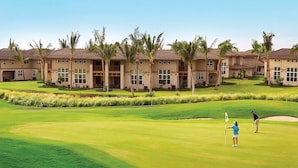 A golf course with a clubhouse and palm trees. - Waikoloa Colony Villas (Waikoloa)