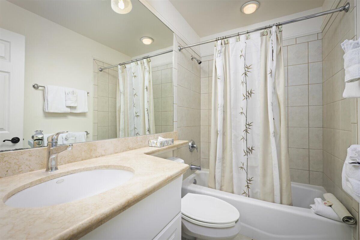A bathroom with a sink, toilet, and bathtub.