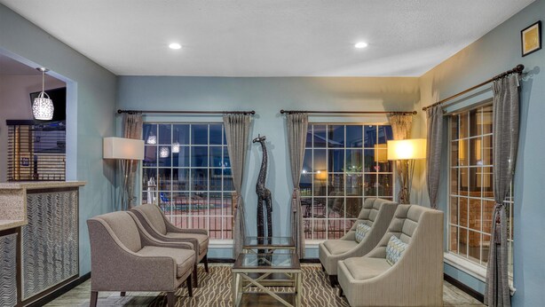 A spacious living room with a large window, a giraffe sculpture, and two sofas. - Best Western Lake Conroe Inn (Montgomery)