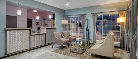 A modern living room with a sofa set, a coffee table, and a decorative mirror.