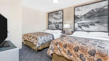 Habitación de hotel con dos camas, un televisor y dos grandes cuadros de paisajes.