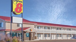 Un motel Super 8 con techo rojo y un cartel grande.