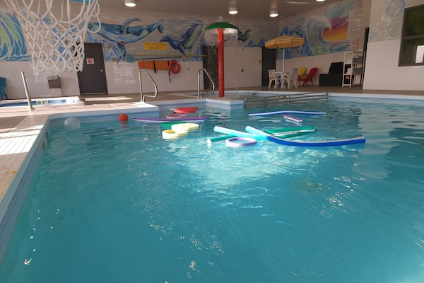 Una piscina techada, sillones reclinables de piscina