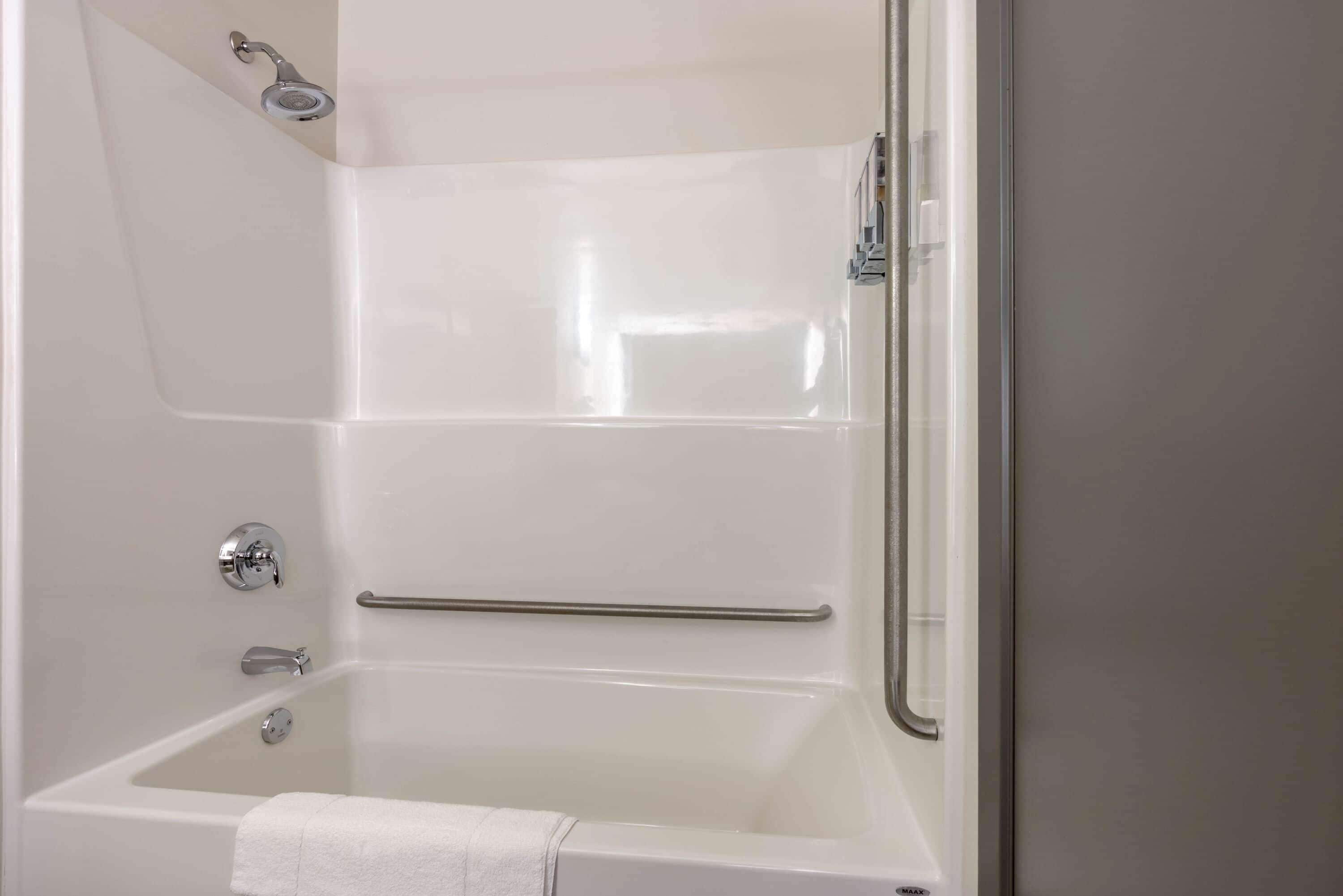 A modern bathroom with a bathtub, a shower, and a glass-enclosed shower area.