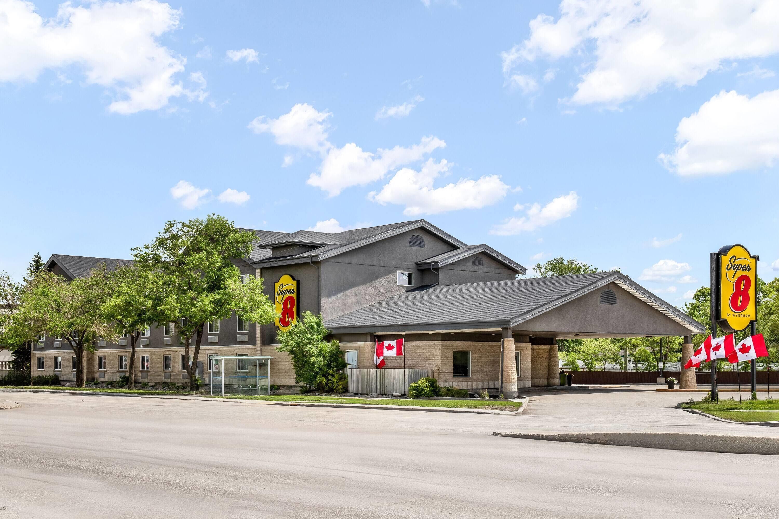 A Super 8 hotel with a parking lot, a gas station, and a bus stop.