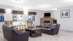 A modern living room with a sofa, armchairs, a coffee table, and a fireplace.
