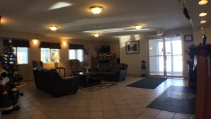 A spacious living room with a fireplace, a Christmas tree, and a television.