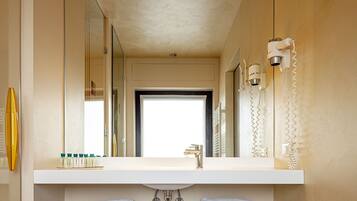 A bathroom with a large mirror, a white vanity, two sinks, and a towel rack.