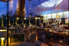 A modern restaurant with a bar area, seating arrangements, and a variety of food and drink options. - Hotel Là di Moret (Udine)