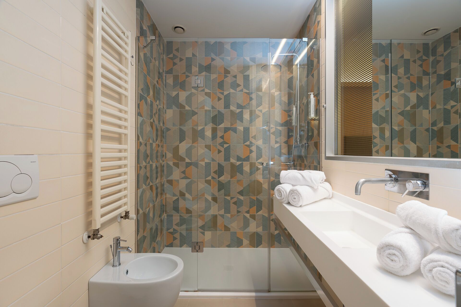 A modern bathroom with a walk-in shower, a sink, and a mirror.